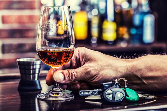 A hand holding a glass of alcohol

Description automatically generated